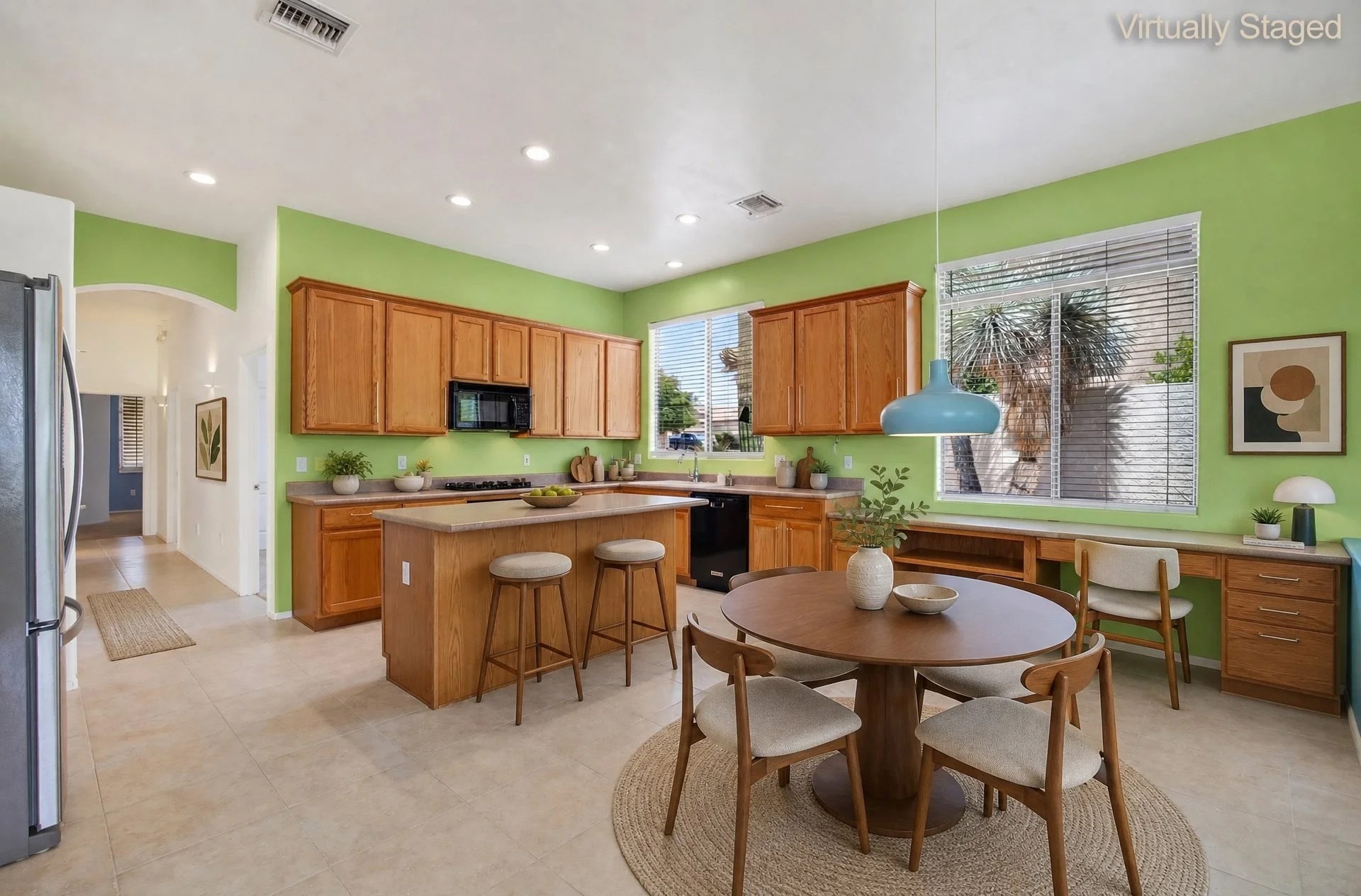 Virtually staged kitchen with wood cabinetry, center island and breakfast nook